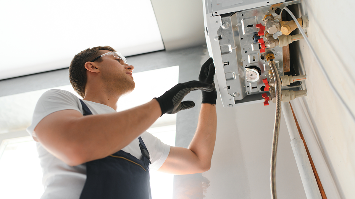 A gas engineer looking at a boiler